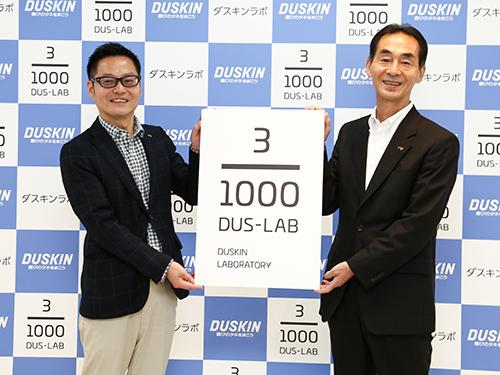 記者発表会で「ダスキンラボ」を掲げる山村社長（写真右)